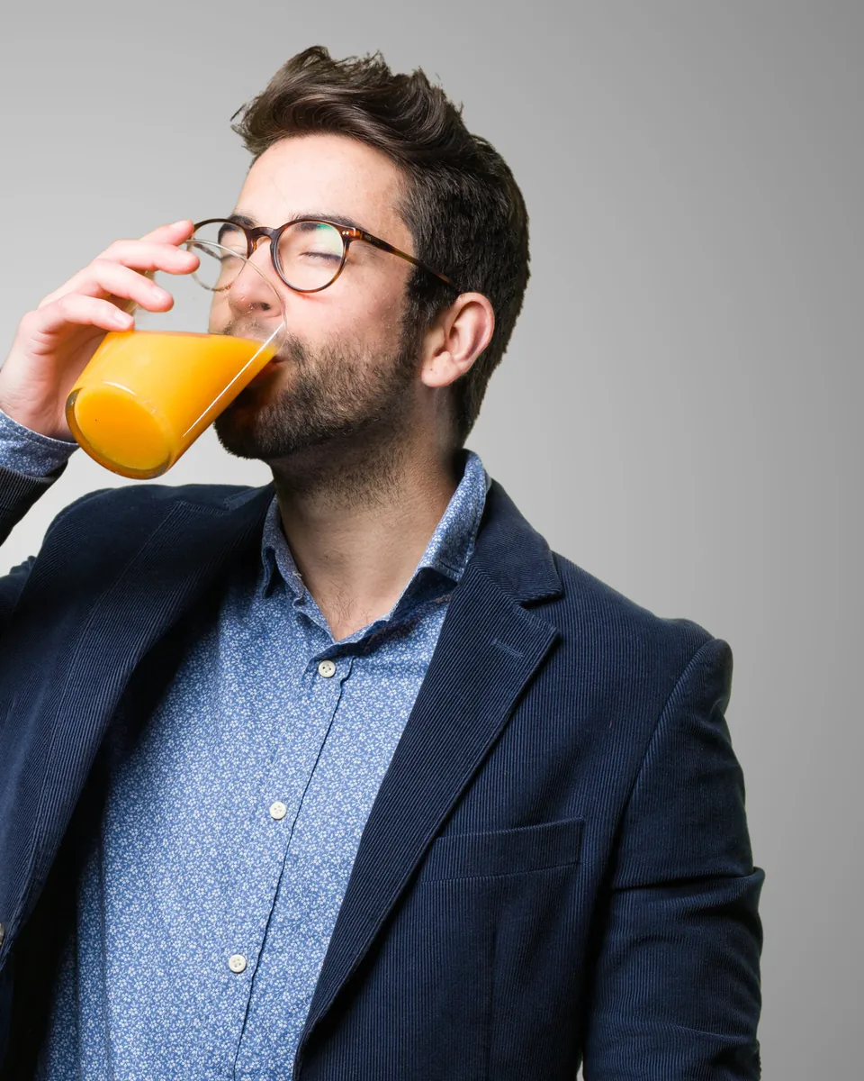 Man drinking a glass of orange juice